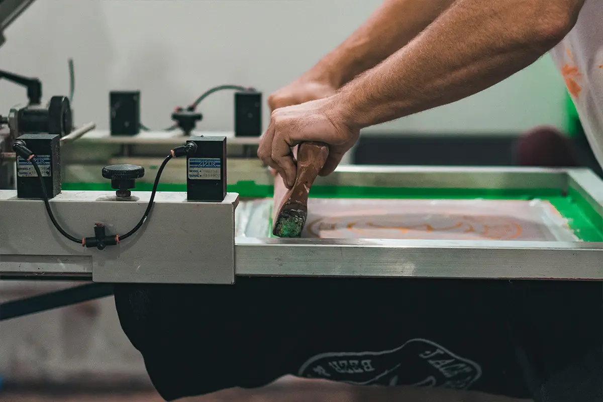 Screen printing process at a professional printing press producing custom branded materials in UAE
